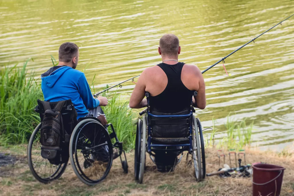 Two disabled friends in wheelchairs fishing